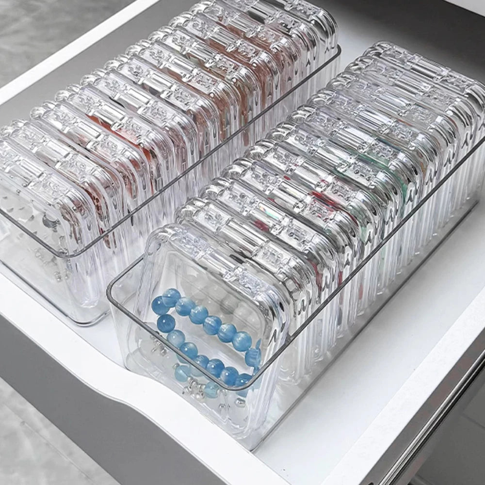 Clear jewelry organizer box with multiple secure compartments arranged in rows