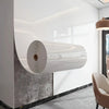 A white cylindrical 3D marble peel-and-stick wall panel mounted on a gray textured wall.