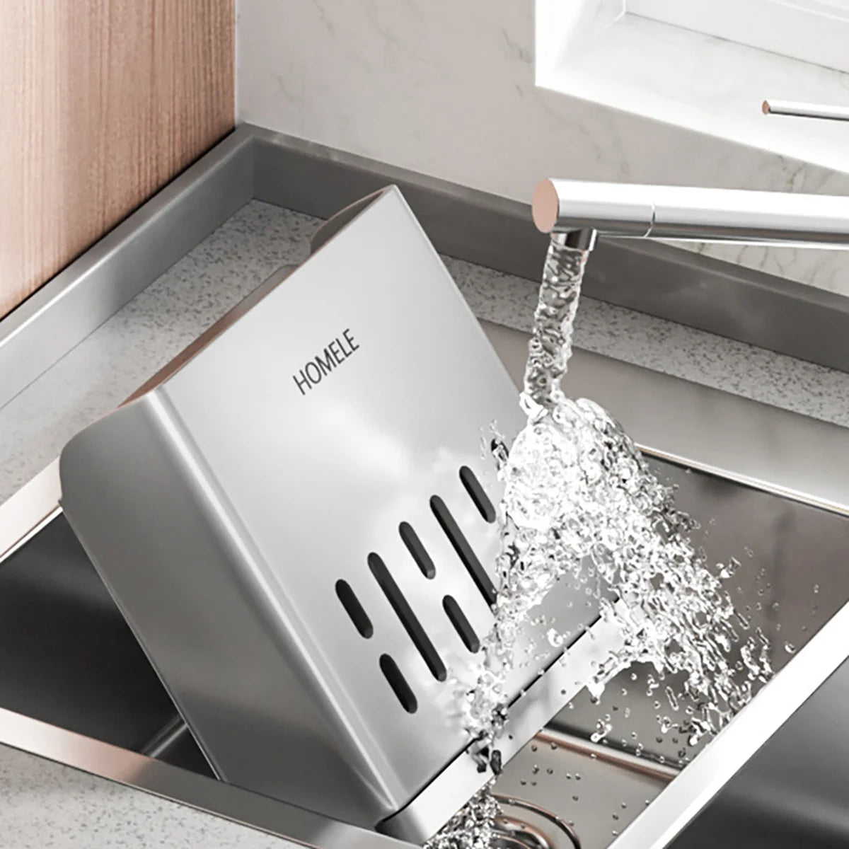 A stainless steel cutlery organizer with a detachable drain tray is shown being used to rinse cutlery.