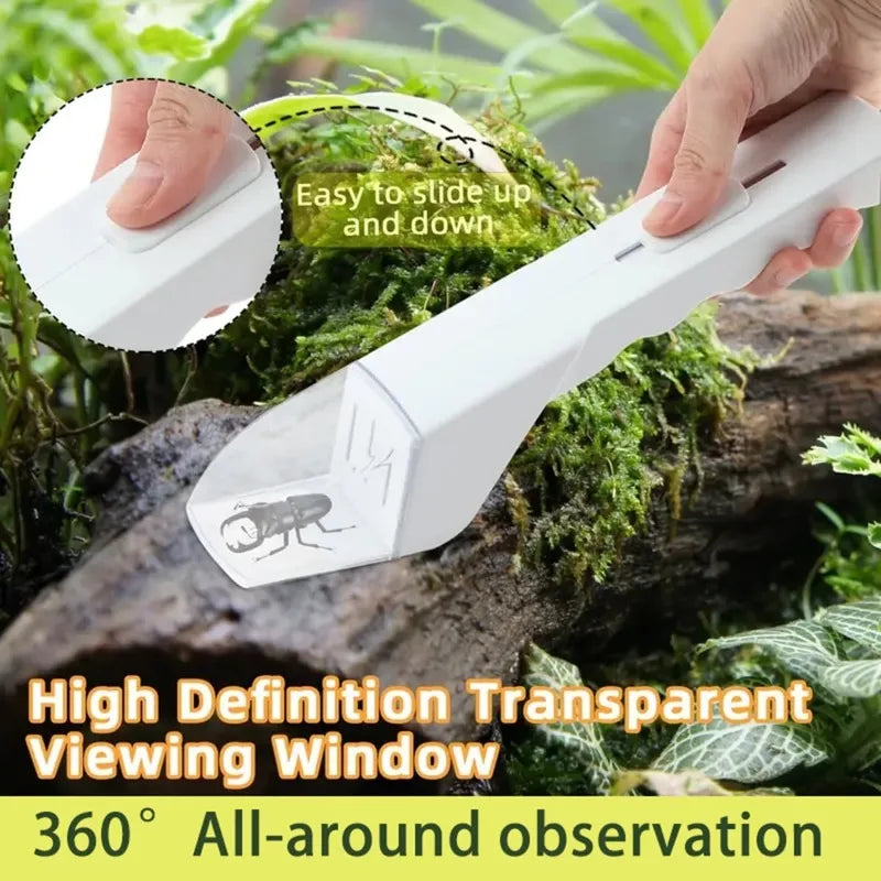 A hand holds a white handheld insect catcher with a transparent viewing window, positioned among green moss and foliage.