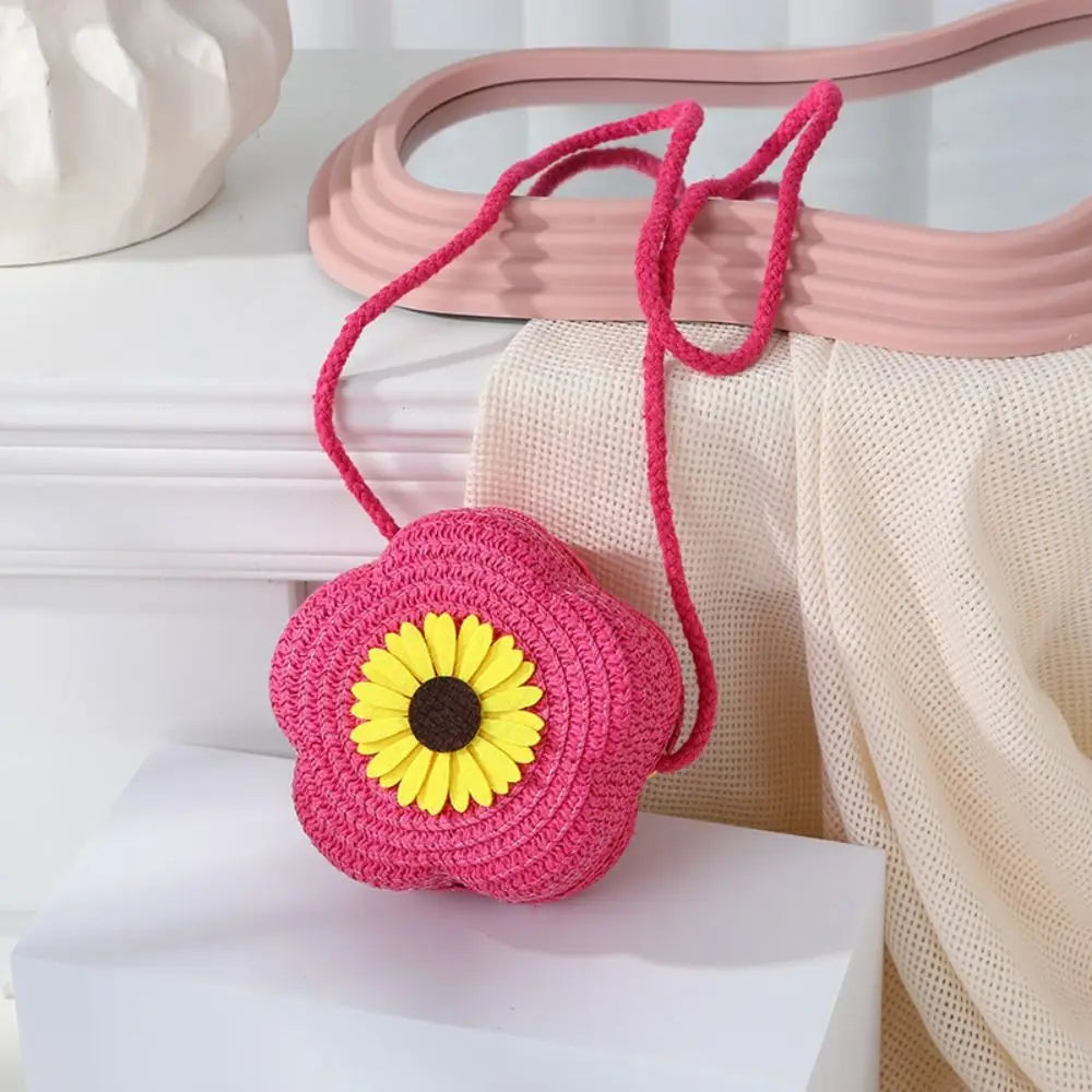 Sac bandoulière en crochet rose avec un centre jaune, exposé sur une surface blanche.