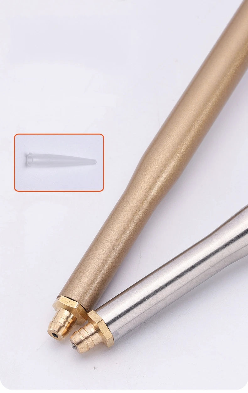 Close-up view of a gold-colored adjustable foam spray gun with a clear tip and metal fitting.