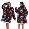 Eine Frau modelliert einen rot-schwarz gemusterten, oversized Fleece-Hoodie mit Totenkopf-Designs.