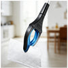 A close-up of a black and blue foldable reacher grabber tool resting on a white cloth in a bright indoor setting.