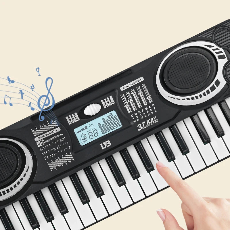 A hand plays a black 37-key electronic piano with an LED display and microphone, showing the keys and soundboard.