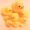 A collection of small, bright yellow duck toys for babies.