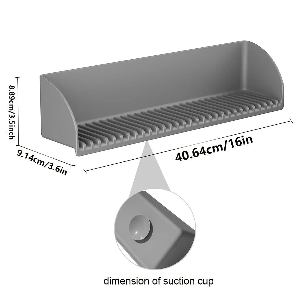 A gray flexible silicone sink splash guard with a suction cup base shown in profile view.
