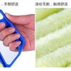 A hand holds a blue plastic dusting brush against a yellow fuzzy surface, demonstrating its smooth feel.
