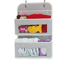 A gray hanging storage organizer with three compartments for holding various items like fabric and toys.