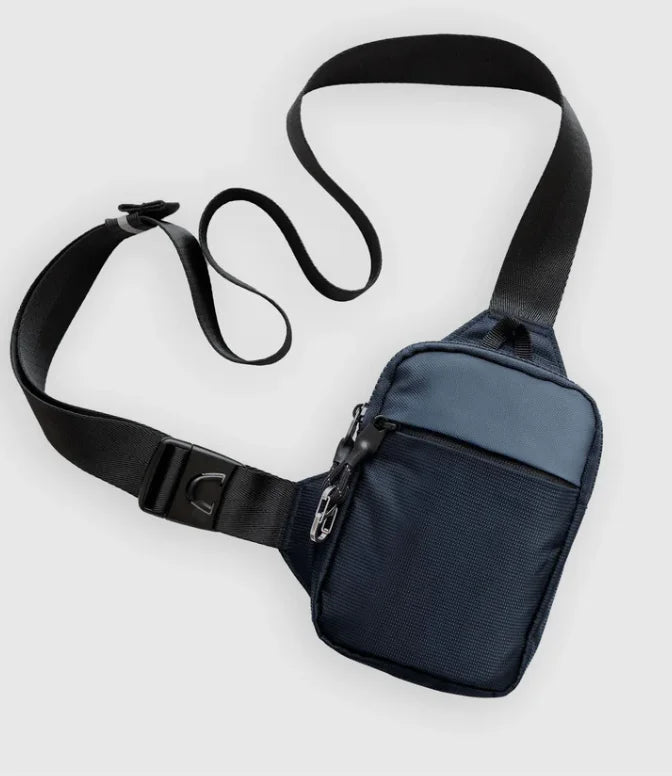 Bolso cruz de nylon azul oscuro con correa y hebilla negra.