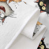 A close-up of a white kitchen towel featuring a cartoon cat design with large eyes and whiskers.