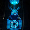 Close-up of a blue LED cup holder light illuminating a glass in a car interior.