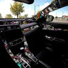 A close-up view of a car interior with a graffiti pattern velvet wrap sticker on the door and dashboard.