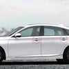 Side view of a white sedan showing door handle protector film on the doors.