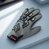 A pair of gray nylon riding gloves with black accents resting on a light blue surface.