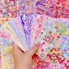 A hand holds a fan of colorful kawaii stickers for journaling and crafts.