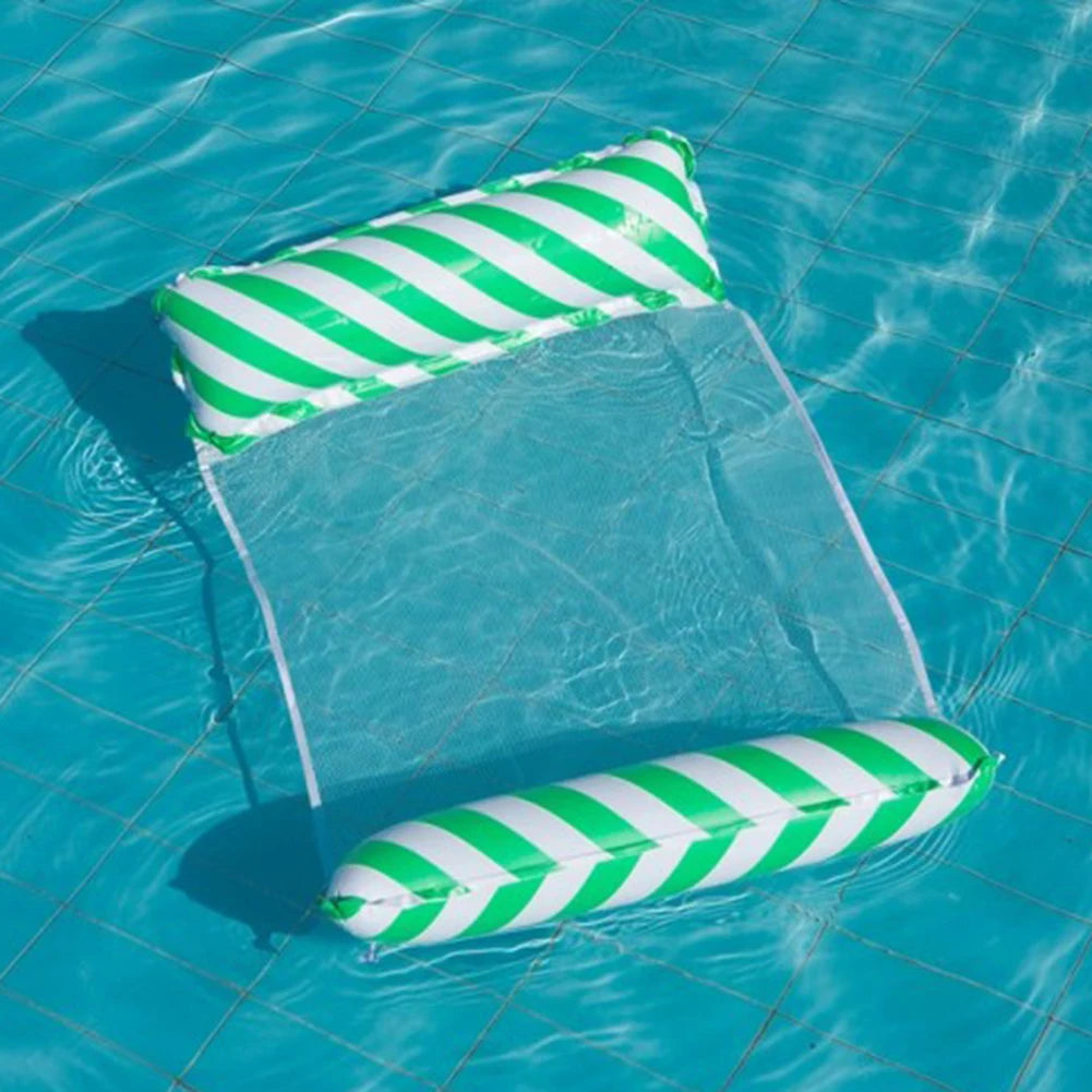 A green and white striped foldable floating water hammock is partially submerged in clear blue water.