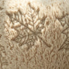 Close-up of a beige faux fur throw pillow cover featuring an embroidered maple leaf pattern.
