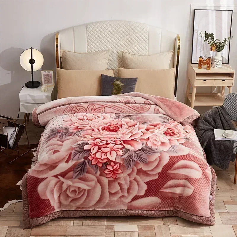 A pink and red floral weighted blanket is displayed on a bed with white bedding and wooden furniture.