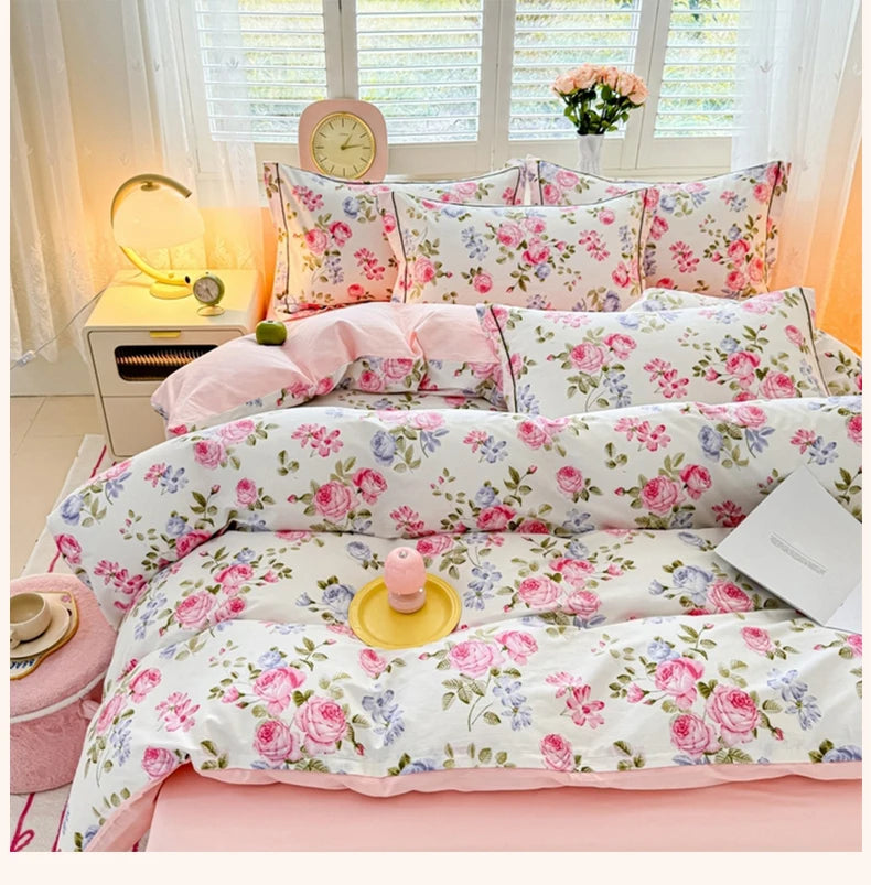 Rosa und weiße Blumen-Kopfteppichhülle mit Rosen- und Lavendernmustern auf einem Bett.
