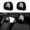A pair of black car headrest covers featuring a creepy face design.