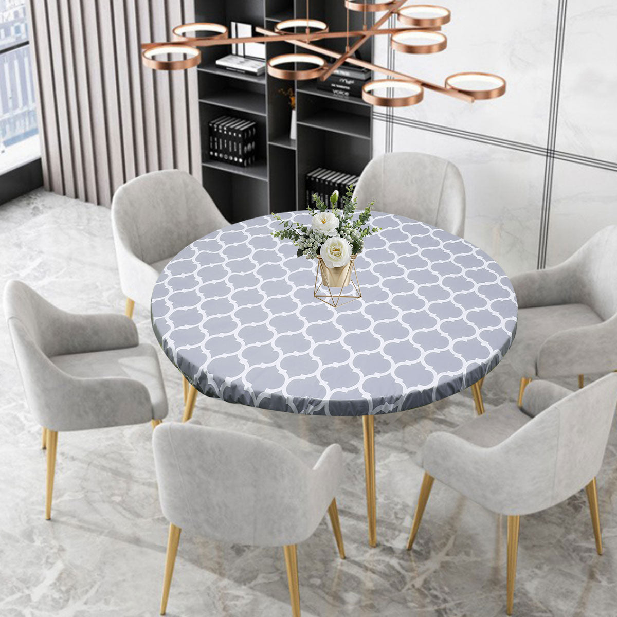A round table set featuring a gray patterned tablecloth, modern chairs, and black shelving.