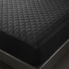 Close-up view of a black quilted waterproof mattress protector with deep pockets.