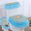 A white toilet seat fitted with a light blue floral fabric cover and a sheer blue tulle skirt.