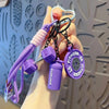 A hand holds a purple and black fitness keychain featuring a purple bottle and fitness theme.