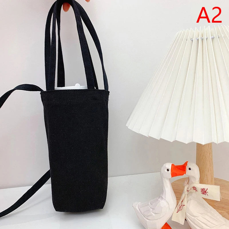 Black canvas crossbody bag hanging next to a white lampshade.