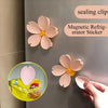 Pink magnetic sealing clips shaped like flowers attached to a refrigerator