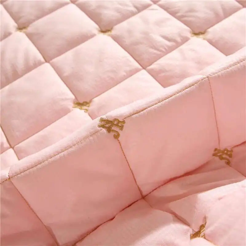 Pink quilted bed skirt with gold embroidery detail