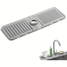 A gray silicone mat with ridges and a central opening used as a splash guard for kitchen or bathroom faucets.