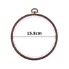 A circular wooden embroidery hoop with a metal hook for cross-stitch and needlework.