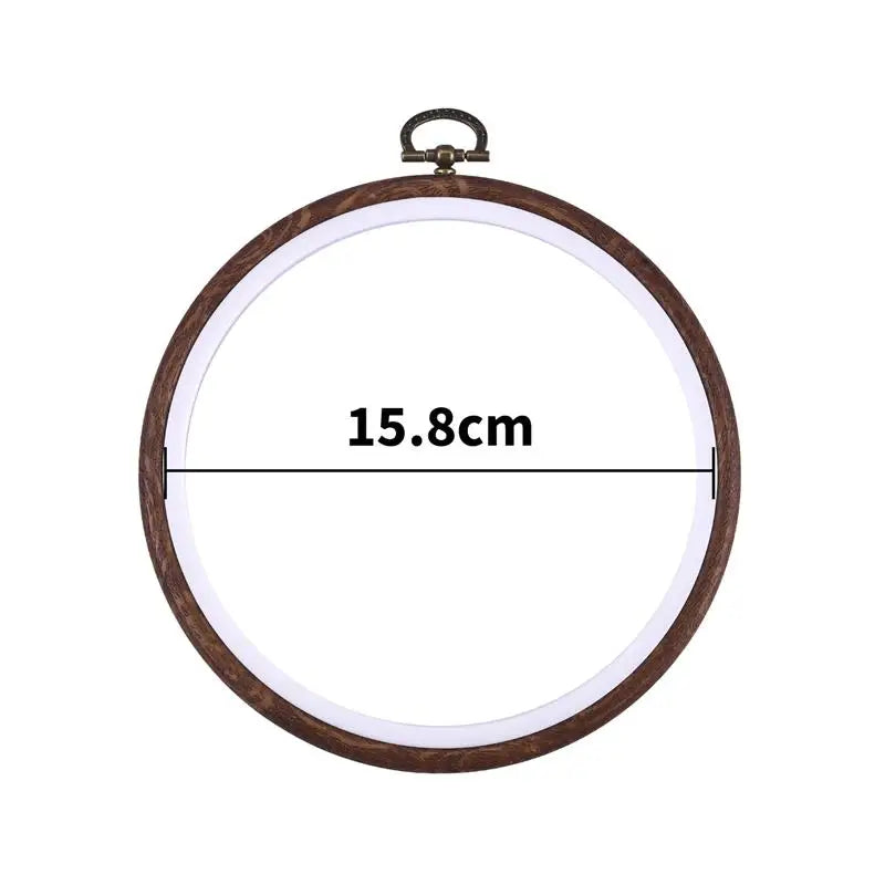 A circular wooden embroidery hoop with a metal hook for cross-stitch and needlework.