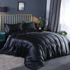 A black silky duvet cover set displayed on a bed with gold accents and dark gray curtains.
