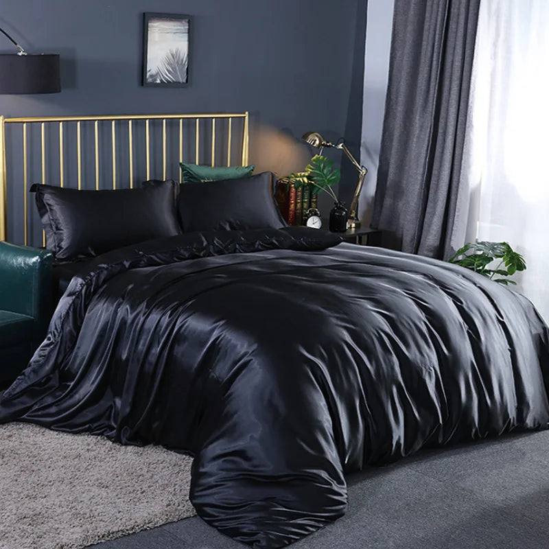 A black silky duvet cover set displayed on a bed with gold accents and dark gray curtains.