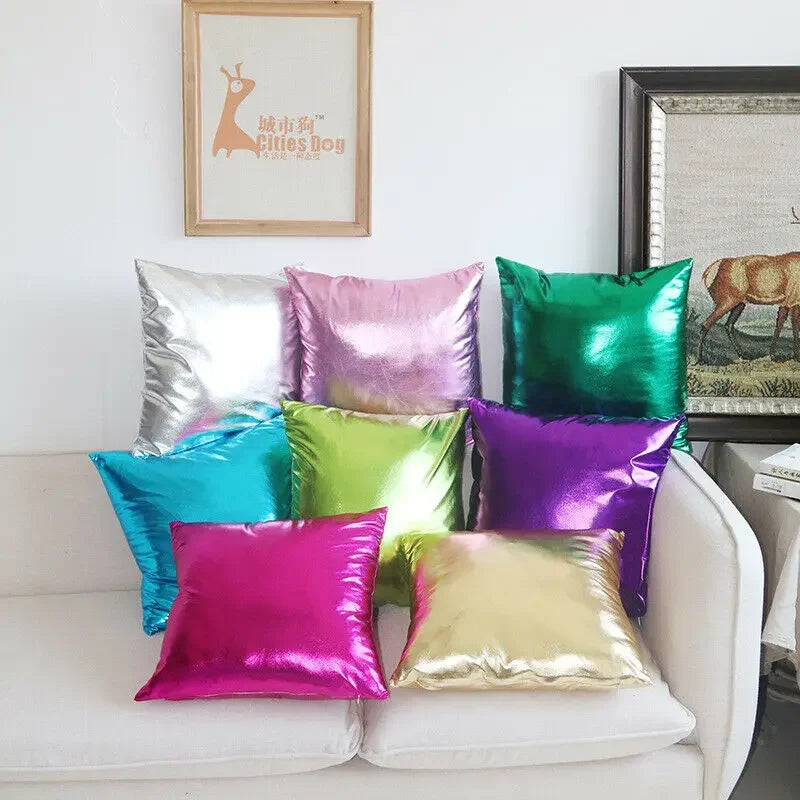 A collection of vibrant metallic pink, green, purple, and gold decorative pillowcases displayed on a white sofa.