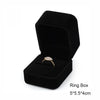 A black velvet ring box containing a gold-toned ring.
