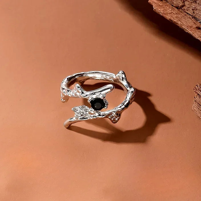 Silver irregular heart ring featuring a black gemstone set in a delicate, organic design.