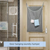 A gray hanging laundry hamper is displayed on a wooden door, featuring metal mounts for storage.