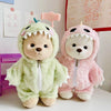 A soft green dinosaur jumpsuit outfit for a medium teddy bear doll with pink accents.