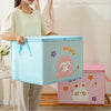 A person holds a light blue foldable storage bag for clothes and quilts, next to a pink version.
