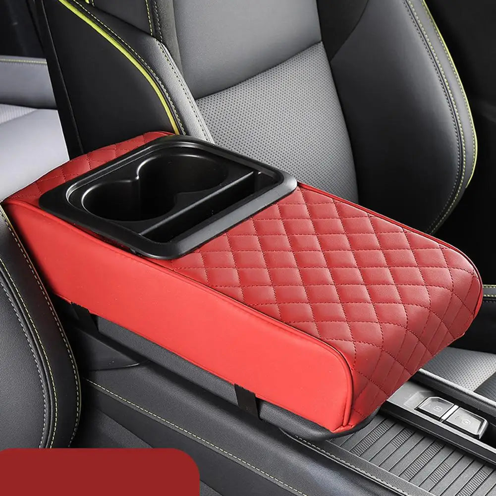 A red quilted armrest cushion with a cup holder is placed on the center console of a car seat.