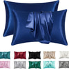 Un juego de fundas de almohada de seda satinada en varios tonos, incluyendo azul, verde, rosa y gris.