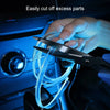 A hand uses a pair of scissors to cut excess parts of a flexible blue LED light strip inside a car interior.