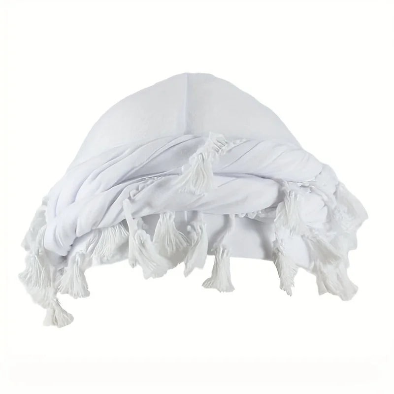 A white vintage twist head wrap with tassels shown from above.