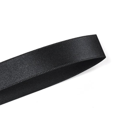 A black double face satin ribbon roll is shown diagonally.