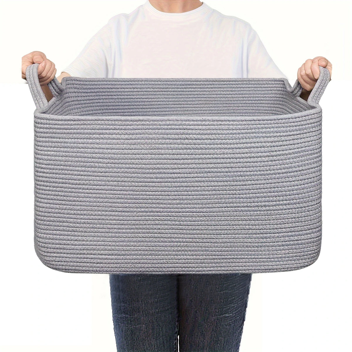 A gray woven cotton rope storage basket being held by a person.