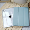 A light blue slim protective iPad case with a built-in pencil holder is shown on a beige fabric.